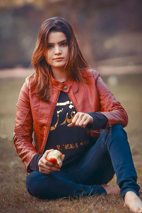 Silent girl seat on grass and apple in hands