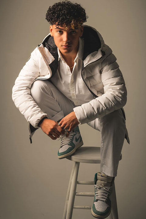 Maximo Rivano is posing for a picture and wearing white jacket.